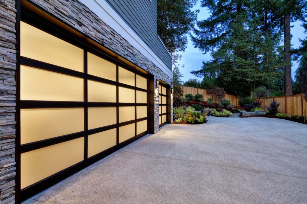 Modern glass-panel garage door at dusk