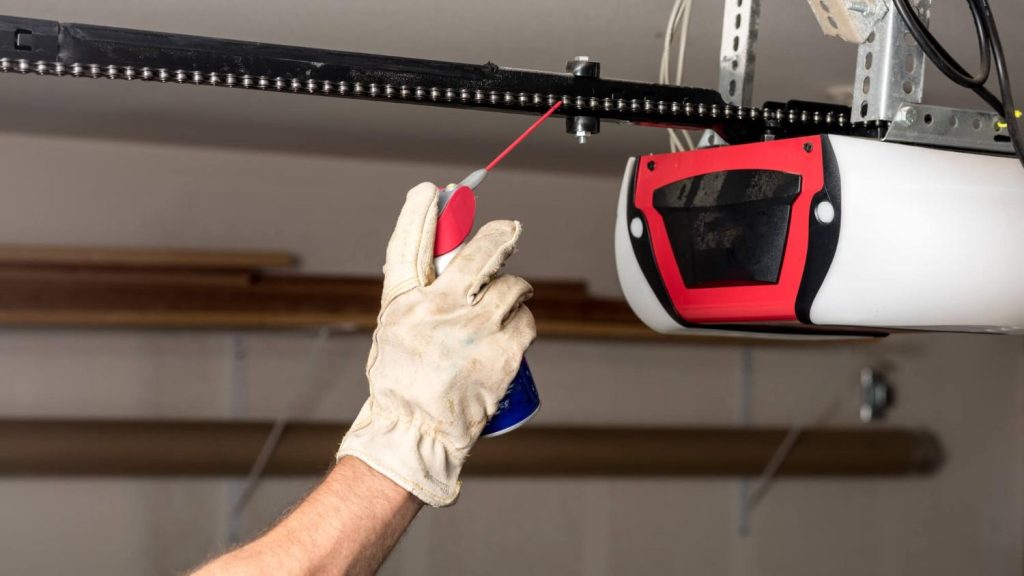 Technician servicing a garage door opener rail