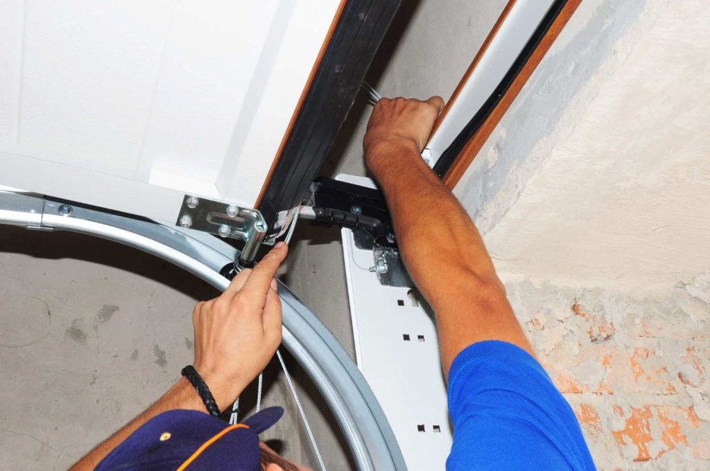 Technician adjusting garage door track hardware